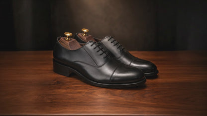 premium leather oxford shoes Standing on a walnut wooden table, Soft focus. spot light. realistic, 4k quality